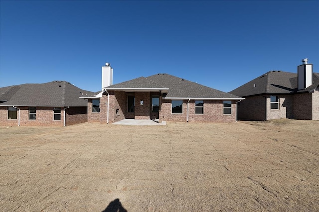 back of house with a patio area and a lawn