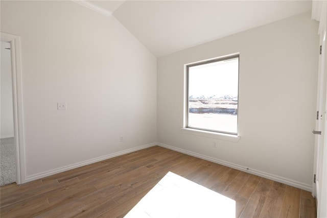 spare room with hardwood / wood-style flooring and lofted ceiling