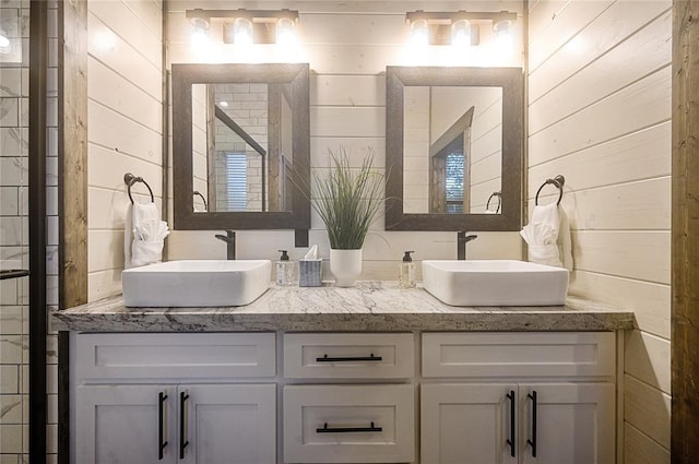 bathroom featuring vanity and wooden walls