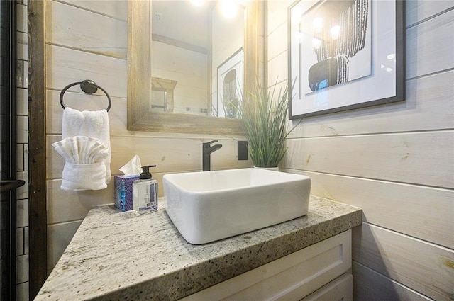 bathroom featuring wood walls and vanity