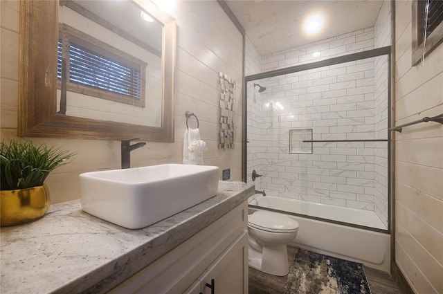 full bathroom featuring toilet, combined bath / shower with glass door, and vanity