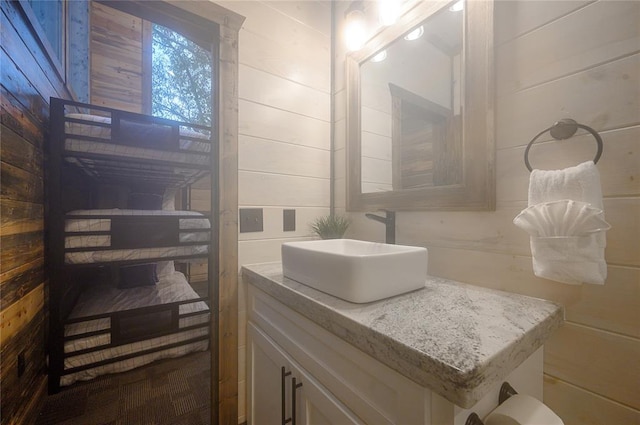 bathroom featuring wood walls and vanity