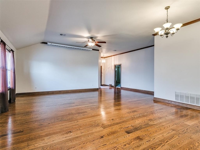 empty room with ceiling fan with notable chandelier, hardwood / wood-style flooring, and vaulted ceiling