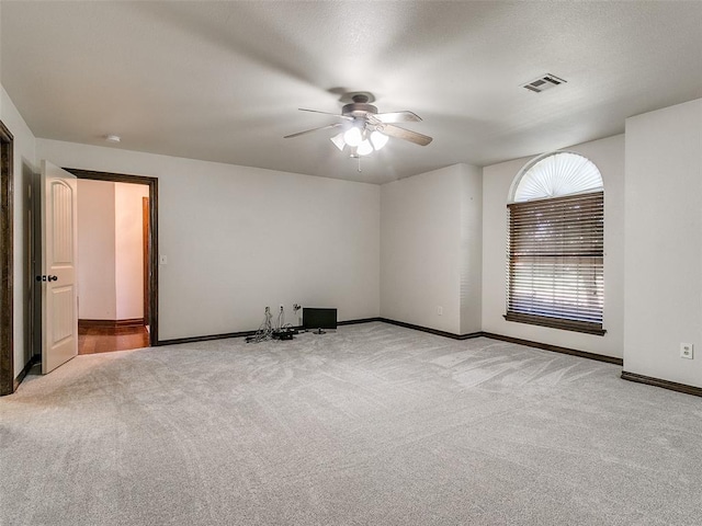 empty room featuring ceiling fan and light colored carpet