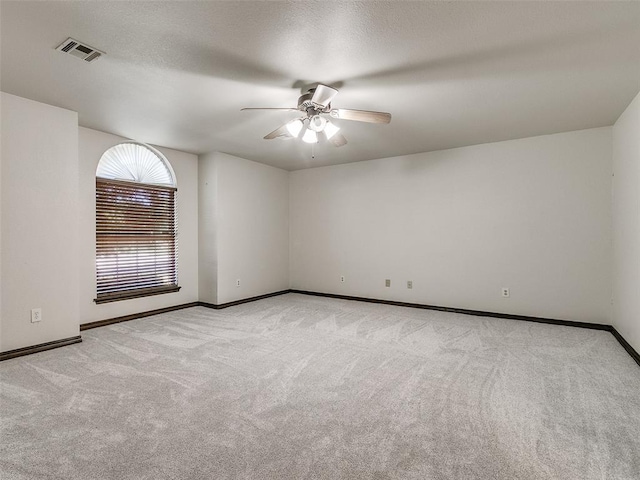 carpeted spare room with ceiling fan and a textured ceiling