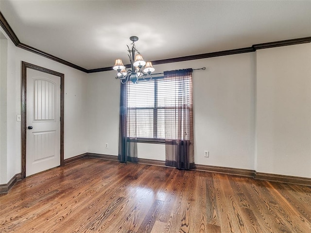 spare room with ornamental molding, dark hardwood / wood-style floors, and a notable chandelier