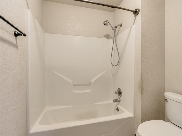 9500 S Brookline Ave, Oklahoma City, OK 73159 - full bathroom featuring toilet, a textured wall, and bathing tub / shower combination
