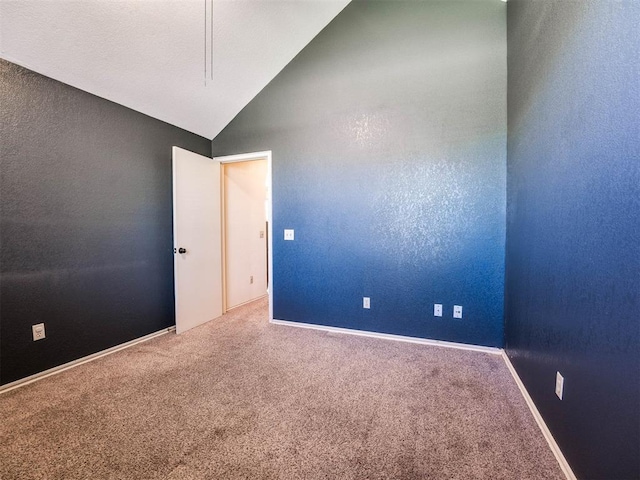 carpeted empty room featuring lofted ceiling