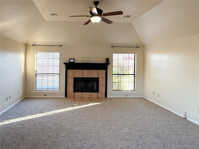 unfurnished living room featuring ceiling fan, lofted ceiling, a fireplace, and carpet floors