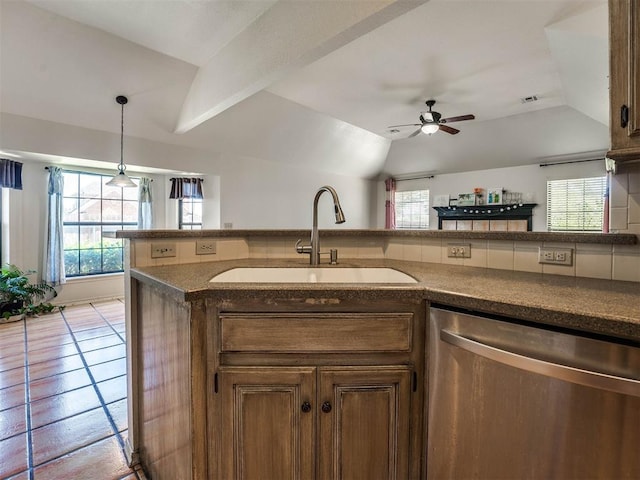 kitchen with sink, a wealth of natural light, vaulted ceiling, and dishwasher