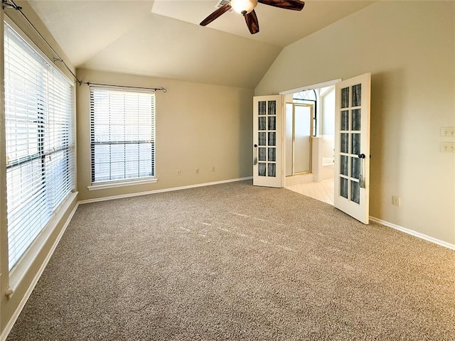 carpeted empty room featuring french doors, ceiling fan, and vaulted ceiling