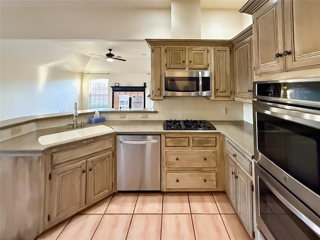 kitchen featuring light tile patterned flooring, sink, ceiling fan, stainless steel appliances, and decorative backsplash