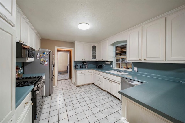 kitchen featuring white cabinets, sink, a textured ceiling, appliances with stainless steel finishes, and light tile patterned flooring