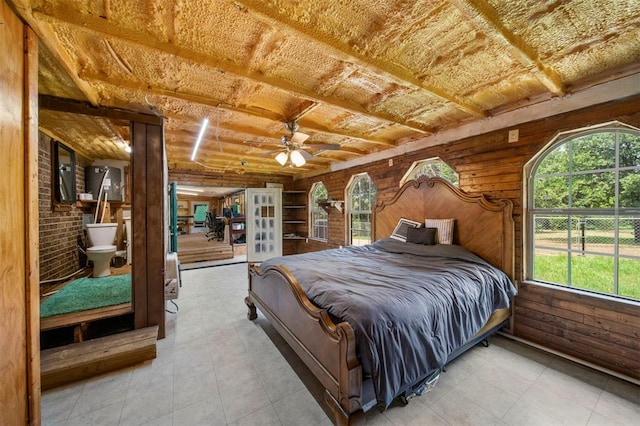 bedroom featuring ceiling fan, ensuite bath, and multiple windows