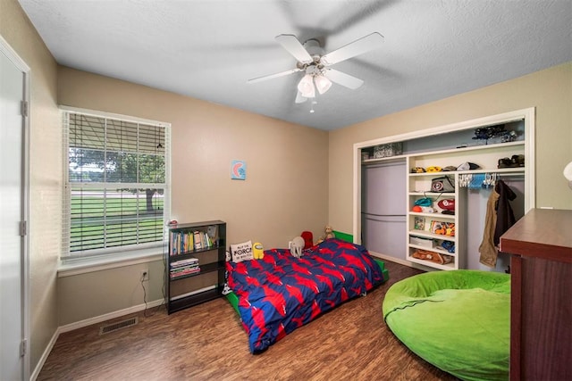 bedroom with ceiling fan, a closet, and hardwood / wood-style flooring