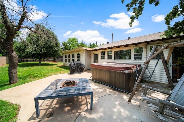 view of patio / terrace with grilling area, a hot tub, and an outdoor fire pit