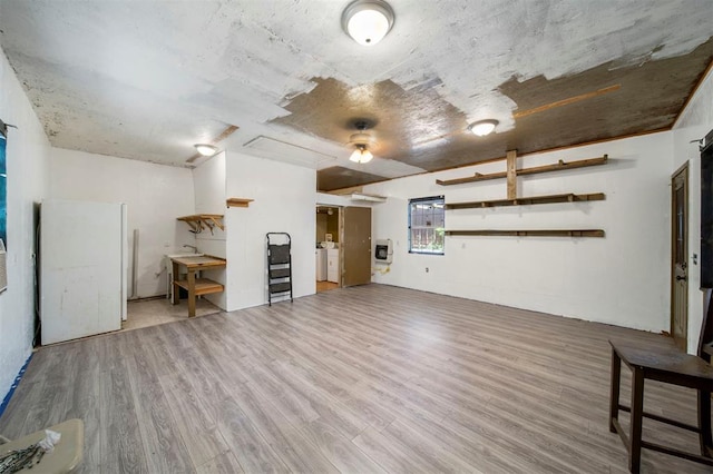 unfurnished living room featuring heating unit, hardwood / wood-style floors, and independent washer and dryer