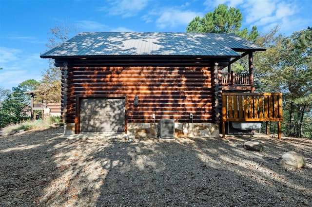 view of property exterior with a garage, a deck, and central air condition unit