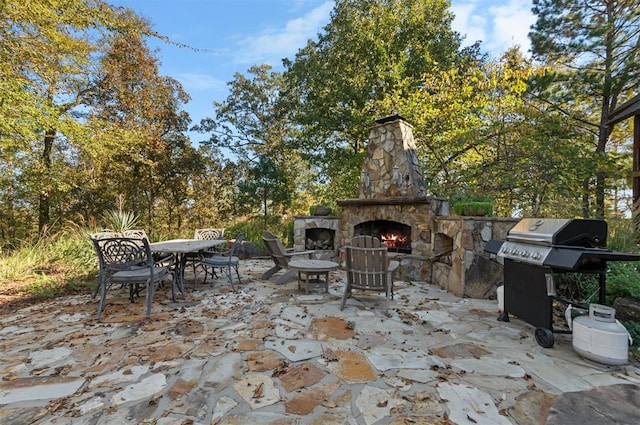 view of patio / terrace with area for grilling and an outdoor stone fireplace