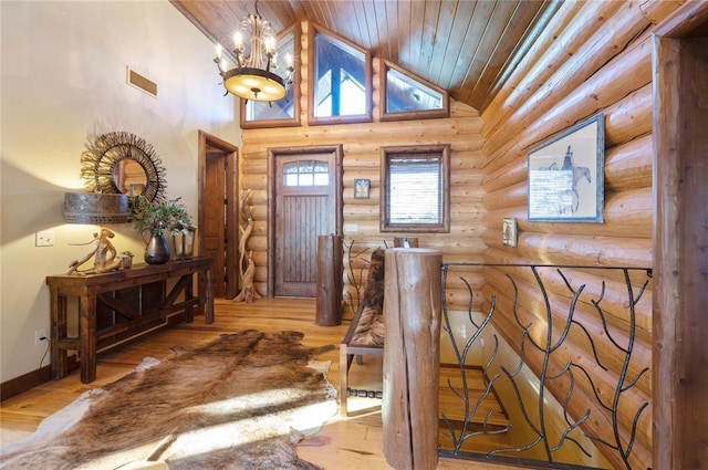 foyer entrance featuring rustic walls, an inviting chandelier, wood ceiling, and light wood-type flooring