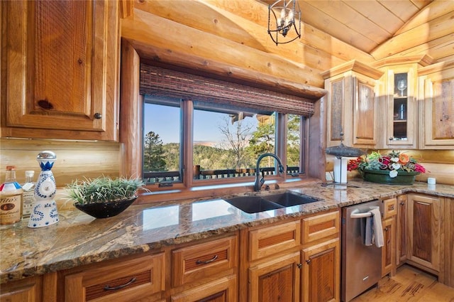 kitchen featuring light stone countertops, stainless steel dishwasher, lofted ceiling, and sink