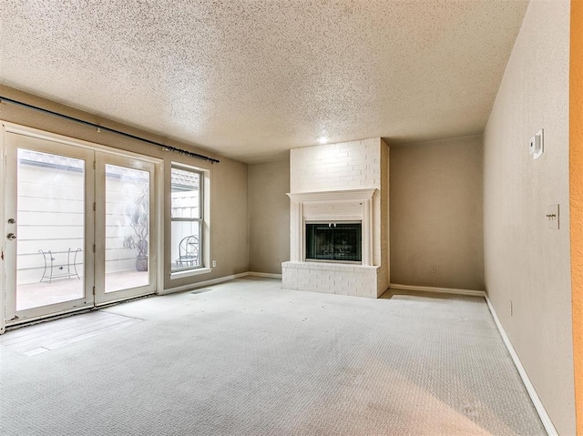 unfurnished living room featuring a textured ceiling, light colored carpet, and a brick fireplace