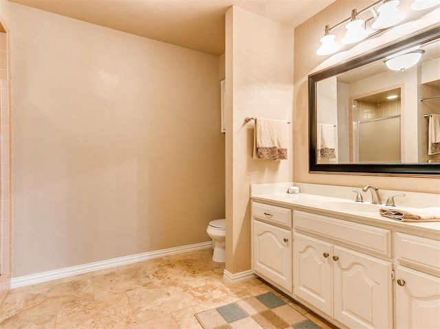 bathroom featuring vanity, toilet, and a shower with door