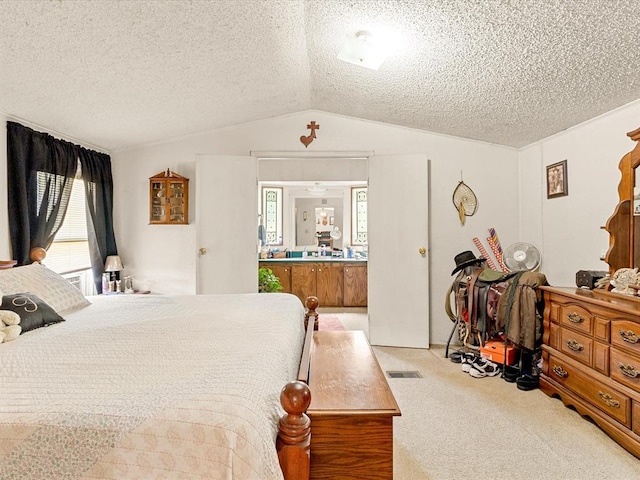 bedroom with a textured ceiling, light carpet, and vaulted ceiling