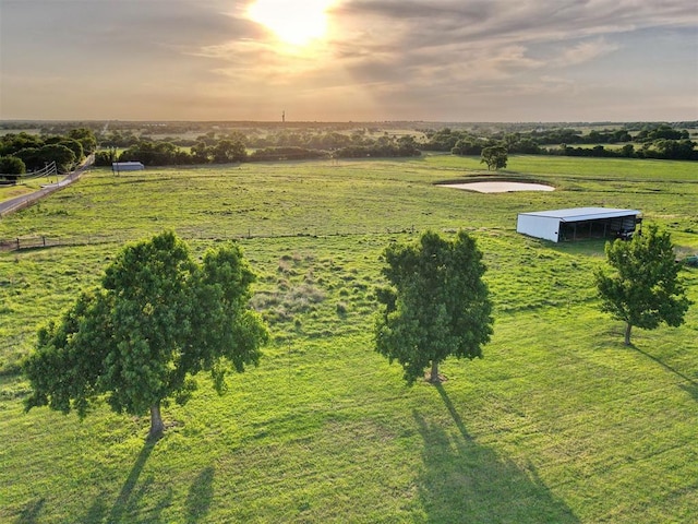 aerial view at dusk featuring a rural view