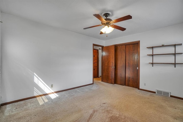 unfurnished bedroom featuring light carpet, a closet, and ceiling fan