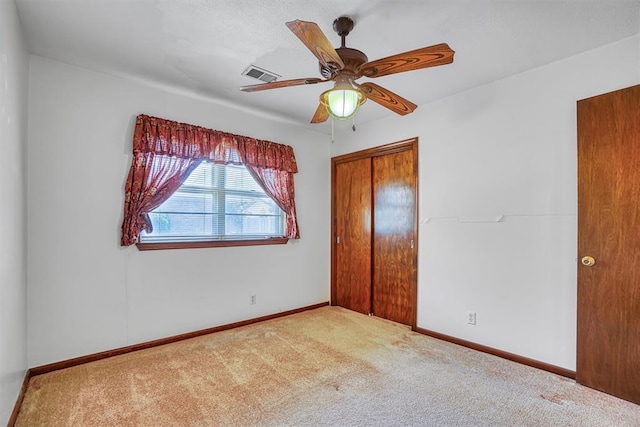 unfurnished bedroom featuring ceiling fan, carpet floors, and a closet