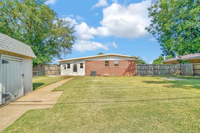 rear view of house featuring central AC, a shed, and a lawn