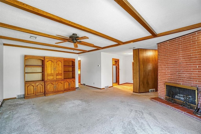 unfurnished living room featuring ceiling fan, light colored carpet, a textured ceiling, and a brick fireplace