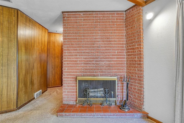 details featuring carpet flooring, wooden walls, and a large fireplace