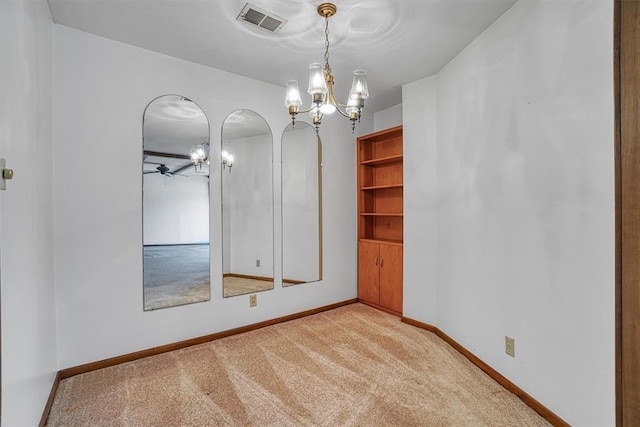 unfurnished room featuring light carpet and ceiling fan with notable chandelier