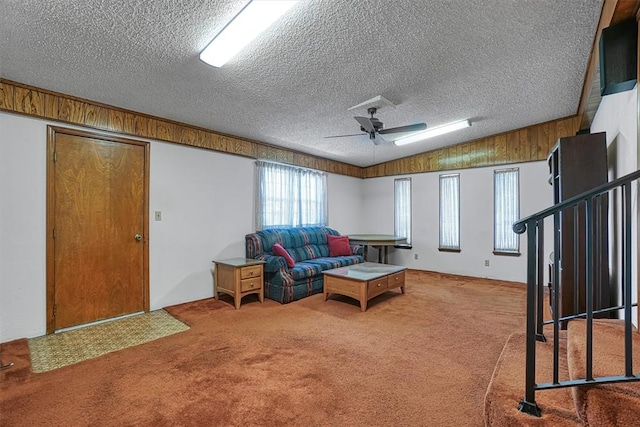 carpeted living room featuring lofted ceiling, ceiling fan, and a textured ceiling