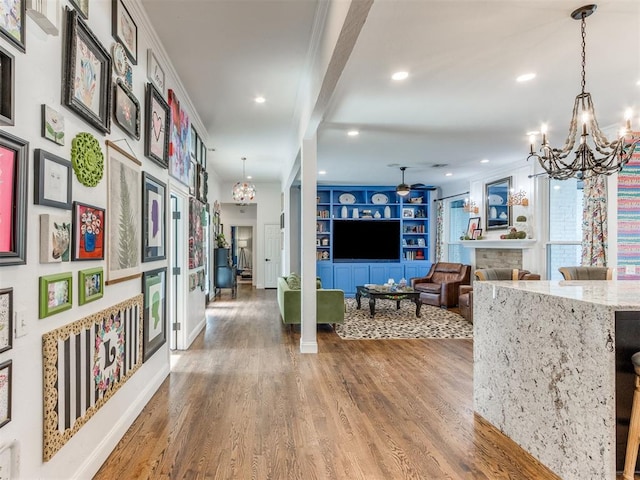 hall with ornamental molding, built in features, a notable chandelier, beamed ceiling, and hardwood / wood-style floors