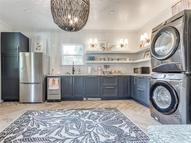 laundry area featuring ornamental molding, light parquet floors, stacked washer / drying machine, and sink