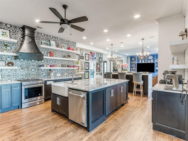 kitchen with light stone countertops, appliances with stainless steel finishes, crown molding, light hardwood / wood-style flooring, and hanging light fixtures