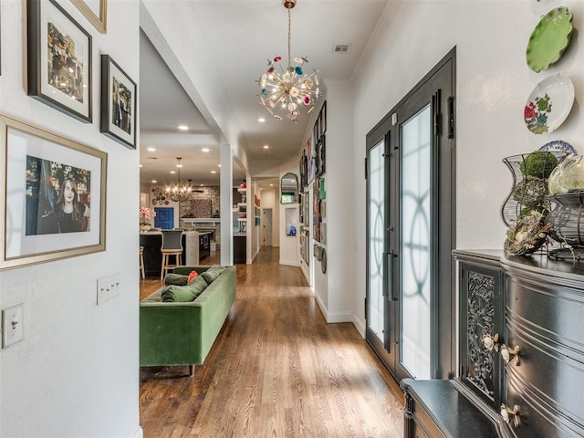 hall featuring a notable chandelier, a healthy amount of sunlight, and dark hardwood / wood-style floors