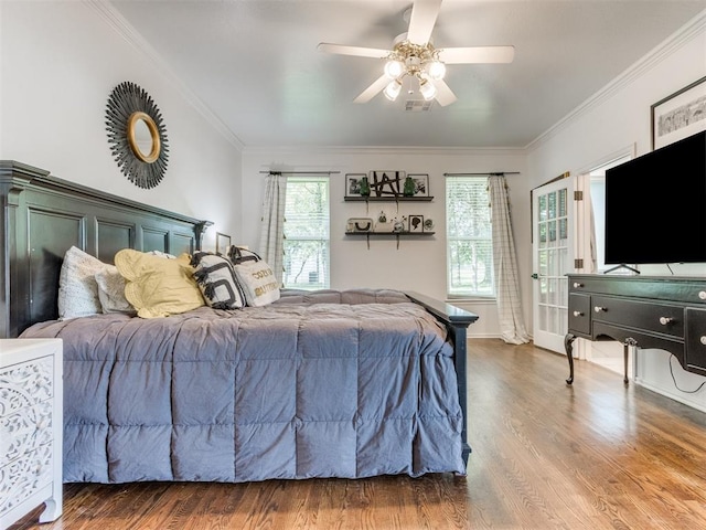 bedroom featuring hardwood / wood-style flooring, ceiling fan, and crown molding