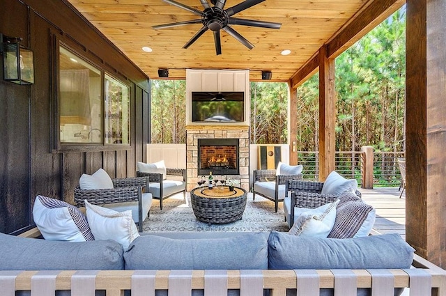 view of patio with an outdoor living space with a fireplace and ceiling fan