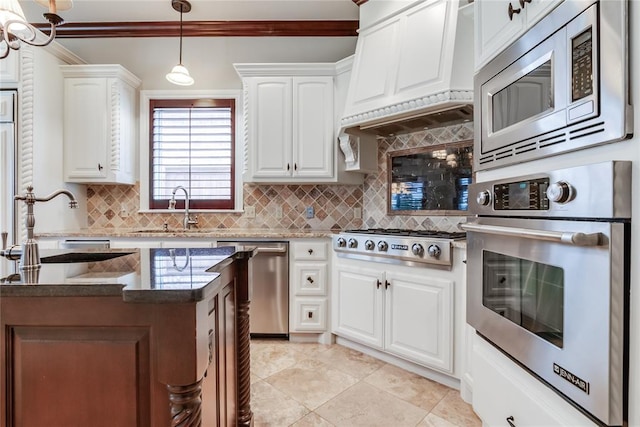 kitchen with white cabinetry, sink, tasteful backsplash, custom range hood, and appliances with stainless steel finishes