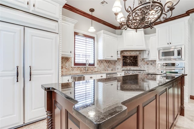 kitchen with stainless steel appliances, decorative light fixtures, a notable chandelier, white cabinets, and a center island