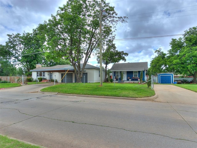 single story home with a front yard, a porch, a garage, and an outdoor structure