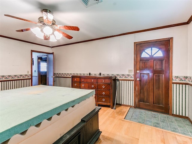 foyer featuring ceiling fan, light hardwood / wood-style flooring, and crown molding