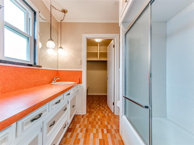 bathroom featuring vanity and bath / shower combo with glass door