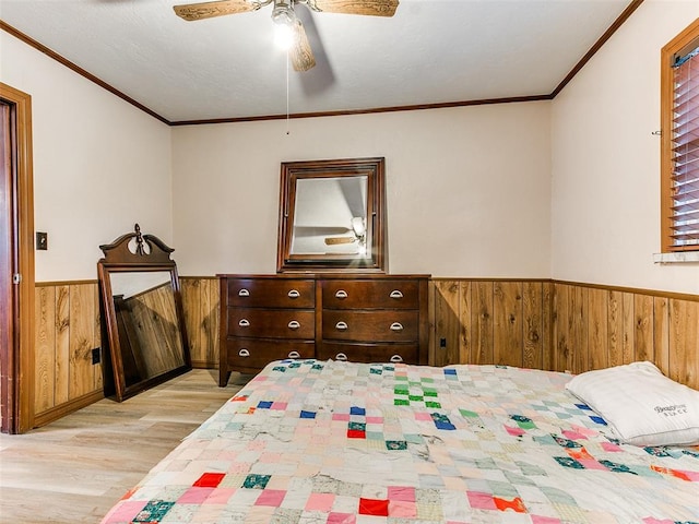 bedroom with light hardwood / wood-style flooring, ceiling fan, crown molding, and wood walls