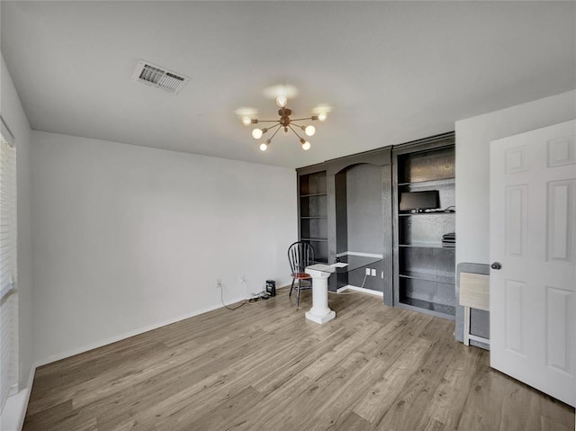 unfurnished bedroom with hardwood / wood-style floors and an inviting chandelier