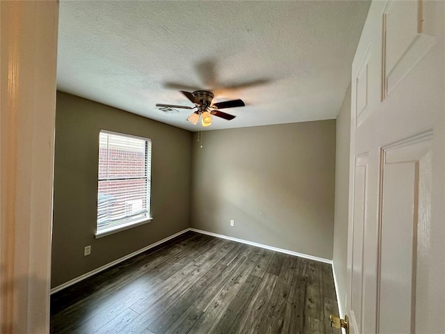 spare room with ceiling fan, dark hardwood / wood-style flooring, and a textured ceiling